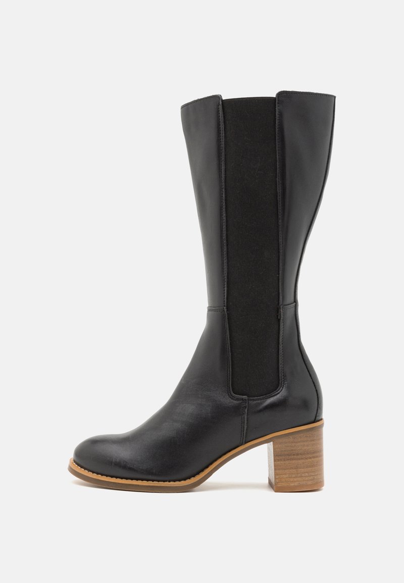 Bota negra de cuero hasta la rodilla con paneles laterales elásticos, puntera redonda y un tacón de bloque de madera texturizada. Acabado suave con detalles mínimos.