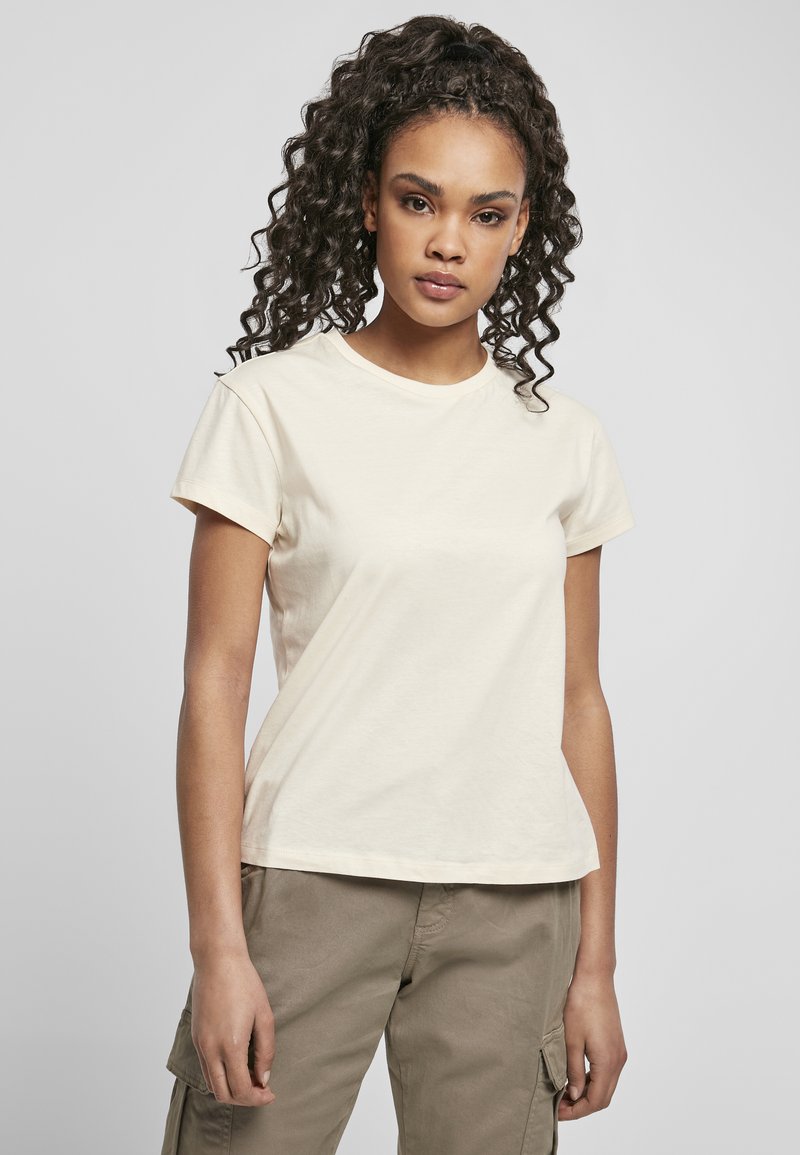 T-shirt corto color beige chiaro in morbido cotone, con collo rotondo e vestibilità comoda, abbinato a pantaloni cargo color khaki.