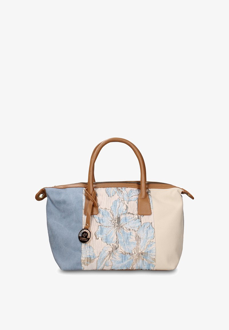 Sac à main rectangulaire avec des panneaux en tissu bleu, beige et floral, des poignées en cuir marron et un pendentif rond noir attaché à une poignée.