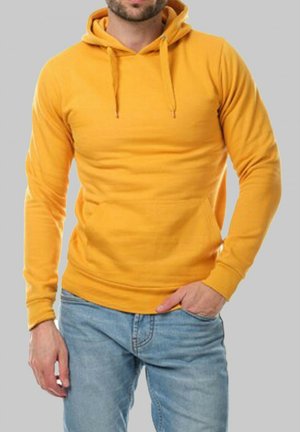 Hoodie jaune en coton, avec une poche frontale, un capuchon à cordon et des poignets côtelés. Porté avec un jean bleu clair.