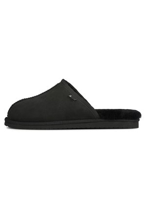 Black suede slipper with a soft fur lining, rounded toe, and flat rubber sole. Features a stitched edge and a small logo accent.