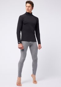 Black long-sleeve turtleneck top paired with light grey fitted leggings, made from stretchy fabric, featuring a smooth texture and minimalistic design.