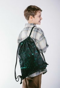 Sacca nera con coulisse dotata di una texture lucida e paillettata, caratterizzata da motivi di codice binario verde. Design leggero adatto per un uso casual.
