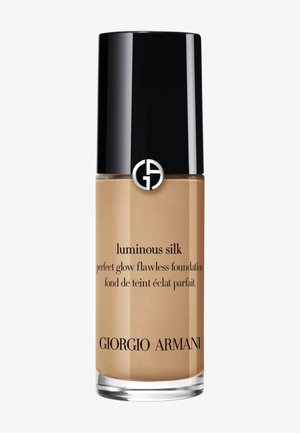Flacon de fond de teint Giorgio Armani Luminous Silk beige avec bouchon noir et logo argenté sur fond uni.