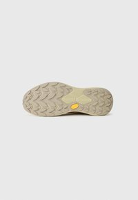 Semelle extérieure Vibram avec un profilé de tread, arborant un logo jaune, de couleur principalement beige avec une surface texturée pour une meilleure adhérence et durabilité.