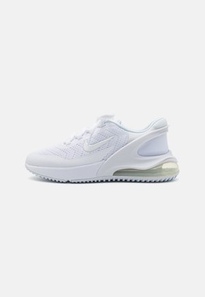 Baskets de sport blanches avec dessus en mesh, semelle rembourrée, unité d’air visible au talon et fermeture à lacets sur fond uni.