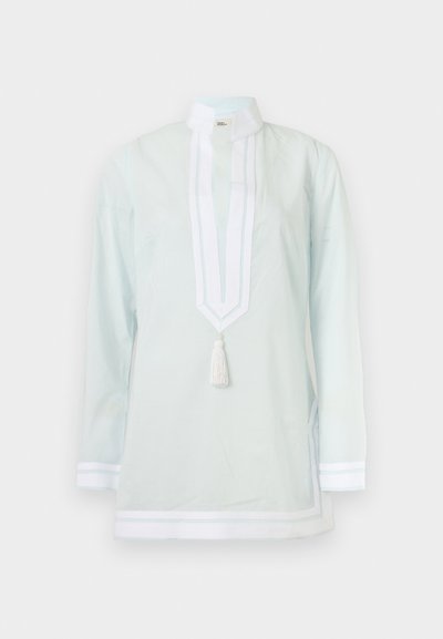 Λευκή μακρυμάνικη τουνίκ με ψηλό γιακά, διακοσμητική λωρίδα και λεπτομέρεια με φούντες μπροστά, με διακριτικό λευκό τελείωμα στα μανίκια και στο κάτω μέρος.