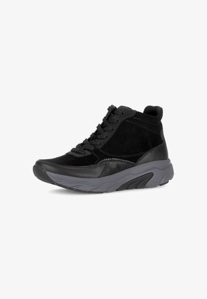 Baskets noires de sport avec un mélange de daim et de matériaux synthétiques. Design montants, fermeture à lacets et semelle en caoutchouc gris texturé.