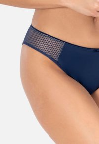 Die marineblaue Bikinihose hat eine einfarbige Vorderseite und einen geometrischen Mesh-Akzent an der Hüfte, der Textur und Designkontrast hervorhebt.