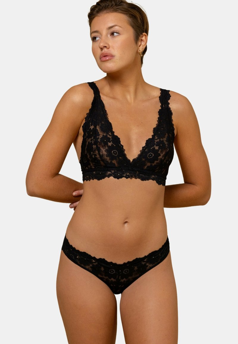 Ensemble de bralette en dentelle noire avec culotte assortie. Comprend un motif floral, des bords festonnés et un décolleté en V profond pour un look délicat.