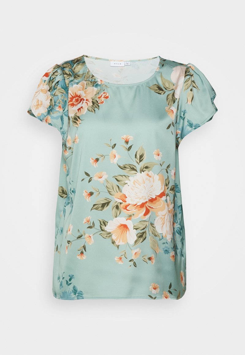 Blouse fleurie en satin vert menthe doux. Elle présente des manches courtes bouffantes et une coupe décontractée avec un motif floral dans des tons corail, crème et vert.