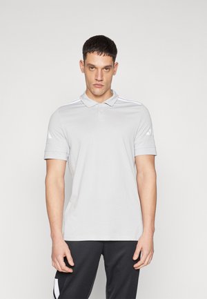 Lys grå polo skjorte med krage, kortermede og tre hvite striper på hver skulder. Stoffet ser glatt og pustende ut.