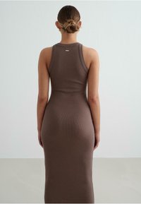 Brown ribbed tank dress with a fitted silhouette, reaching mid-calf. Features a rounded neckline and racerback design.