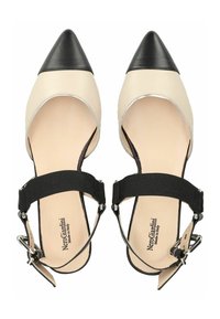 Bailarinas en tonos beige y negro con puntera puntiaguda, tiras elásticas en el tobillo, material de cuero y un capuchón de contraste, con un acento plateado alrededor de la parte superior.