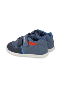 Zapatos de cuero azul con un acabado texturizado, correa de Velcro, suela blanca y acentos en rojo y azul claro; diseñados para comodidad y apoyo.