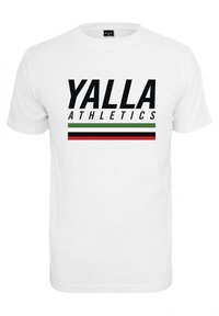 Bílé bavlněné tričko s výrazným nápisem "YALLA ATHLETICS" v tučném černém písmu a vodorovným pruhovaným vzorem v zelené, červené a černé barvě.