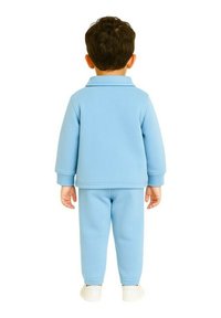 Ensemble de jogging bleu clair pour tout-petit comprenant un haut à manches longues avec col et un pantalon assorti, fabriqué en tissu doux avec des poignets et une taille élastiques.