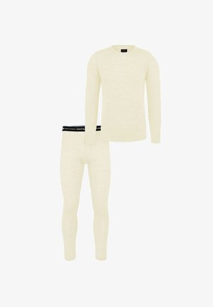 Beiges langärmliges Thermoshirt und passende enganliegende Thermohose mit schwarzem Bund, der weißen Markentext trägt.