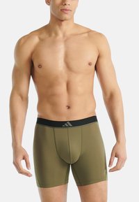 Miesten bokserialushousut oliivinvihreästä kankaasta. Musta joustava vyötärönauha, jossa logo. Lyhyt malli, istuvat lahkeet ja sileä pinta.
