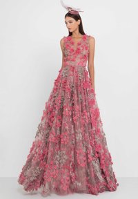 Maxikleid aus transparentem Stoff mit 3D-Blumenapplikationen in Rosa- und Beigetönen. Es verfügt über einen tiefen V-Ausschnitt und einen fließenden Rock.