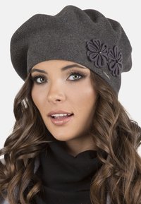 Berretto in maglia grigio con tre applicazioni di fiori scuri. Tessuto a maglia con vestibilità ampia, accentuato da un dettaglio di hardware decorativo in argento.
