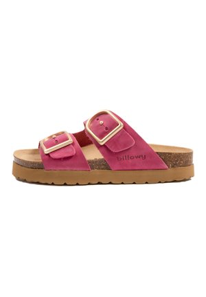 Sandales en suède rose avec deux boucles dorées, une semelle intérieure en liège et une semelle en caoutchouc brun. Caractéristiques d'une texture lisse et de sangles ajustables.