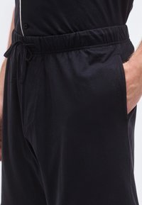 Μαύρο παντελόνι τζόγκερ με ελαστική μέση και κορδόνι, διαθέτει πλαϊνές τσέπες και απαλό, λείο ύφασμα.