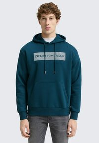 Teal hoodie met een kangaroo zak, voorzien van een grijze grafische logo op de borst. Trekkoord en geribbelde manchetten verbeteren de ontwerpdetails.