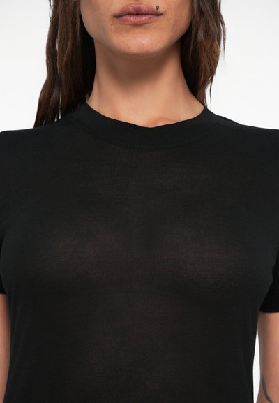 Tricou negru, ajustat, realizat din material moale și transparent. Dispune de un guler rotund clasic și mâneci scurte, oferind o siluetă elegantă.