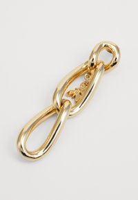 Accesorio de cadena de metal dorado con un acabado liso y brillante. Incluye un pequeño charm con un detalle decorativo dentro de un eslabón.