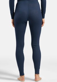 Navy blue fitted leggings made of soft, stretchy fabric. Features a high waistband and ribbed texture, tapering at the ankles.