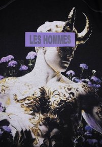 Schwarzes Stoff-T-Shirt mit einem grafischen Druck einer Skulptur mit goldenen Akzenten, umgeben von lila floralen Elementen. Der Text lautet "LES HOMMES."