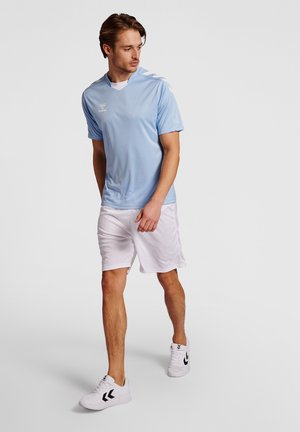 Light blue athletic t-shirt with short sleeves and a v-neck, paired with white shorts. Features logo on the chest and contrasting shoulder stripes.