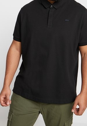Polo noir en mélange de coton, avec un col à revers et des manches courtes. Comprend un petit logo brodé sur la poitrine.