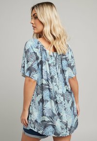 Floral blouse in blue and grey, featuring short sleeves and a relaxed fit with a gathered back. Botanical leaf pattern throughout.