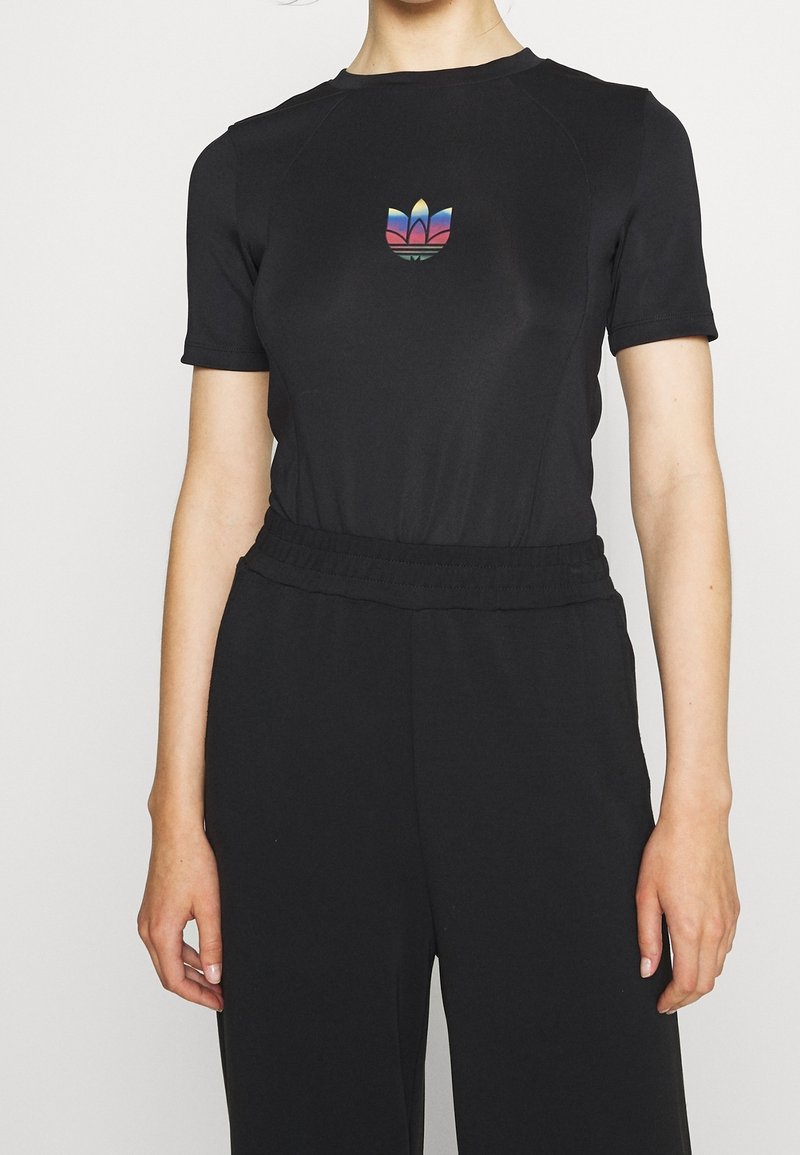 Černý bodysuit s krátkými rukávy vyrobený z pružného materiálu, který má na hrudi vícebarevné logo a elastický pas.