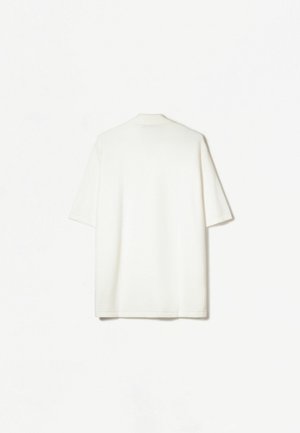 Chemise à manches courtes, coupe décontractée en tissu blanc texturé. Belle col doux et ourlet droit. Design minimaliste, sans motifs visibles.