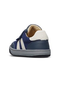 Baskets pour enfant bleues et blanches avec une sangle Velcro, semelle grise et intérieur rembourré, vues de l'arrière sur fond blanc.