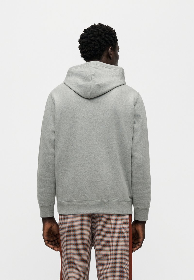 Grå hættetrøje med hætte og ribstrikkede manchetter, der har en blød tekstur. Bær den med ternede bukser for at skabe et lagdelt outfit-look.