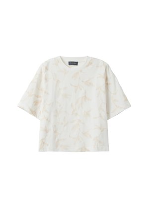 Witte blouse met korte mouwen en ronde hals, met subtiele beige botanische print, losse pasvorm, en een zwart label bij de halslijn.