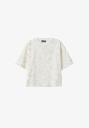 Witte blouse met korte mouwen en ronde hals, met subtiele beige botanische print, losse pasvorm, en een zwart label bij de halslijn.