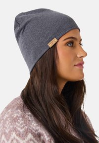 Gray beanie hat made of soft fabric, featuring a simple design and a small label on the side. Smooth texture and form-fitting shape.