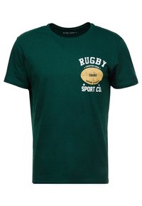 Camiseta de algodón verde con mangas cortas, cuello redondo, que presenta el texto "RUGBY" y un gráfico de un balón de rugby en beige y blanco en el frente.