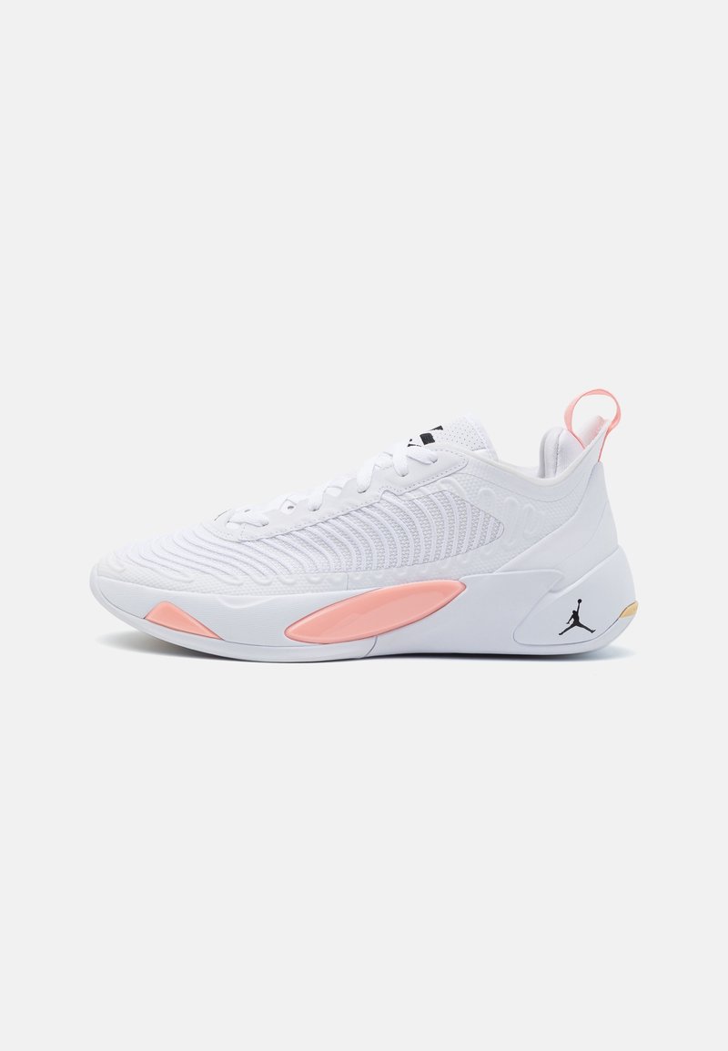 Baskets blanches de sport avec accents roses, dessus texturé, languette au talon et petit logo Jumpman noir sur la semelle blanche.