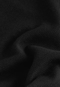Tissu noir avec une texture lisse, présentant de fins motifs tricotés et de doux plissés, montrant de la profondeur et de subtiles variations de lumière.