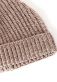 Gorro de punto beige con textura acanalada y un dobladillo para mayor calidez. Hecho de hilo suave y grueso.