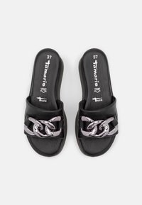 Sandales plates noires avec accents en chaîne métallique, tige en cuir souple et semelle intérieure rembourrée. Taille 37 indiquée à l'intérieur.