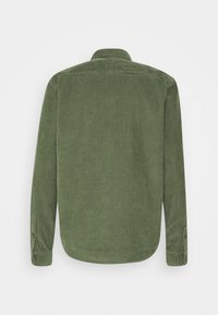 Grön kordflodsskjorta med långa ärmar, med vertikal ribbad struktur och krage. Bakvyn visar knappade manschetter och rundad nederkant.