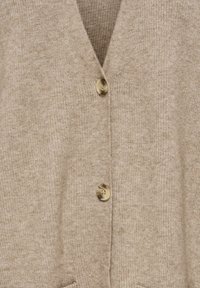 Cardigan beige en tissu tricoté doux avec un col en V, deux boutons et quatre poches. Texturé avec un motif côtelé.