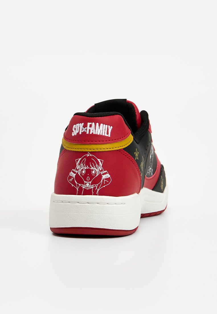 Zapatilla roja y negra con un gráfico de dibujos animados en blanco, cuello acolchado, puntera reforzada y un logo en el talón. Diseño frontal no visible.